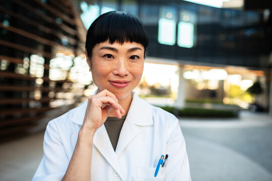 Confident doctor smiling outside modern medical campus