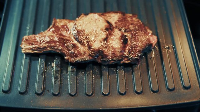 Juicy Beef Steak Frying On Electric Grill Pan Surface