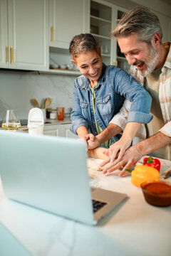 Smiling mature couple cooking together in a modern home kitchen