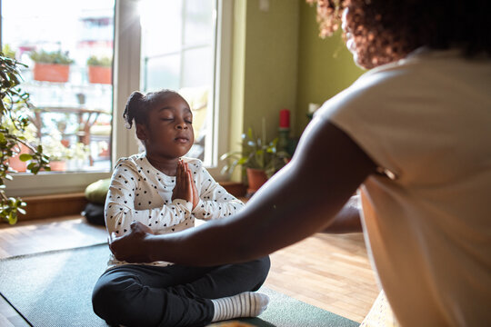 Child practicing yoga with parent at home