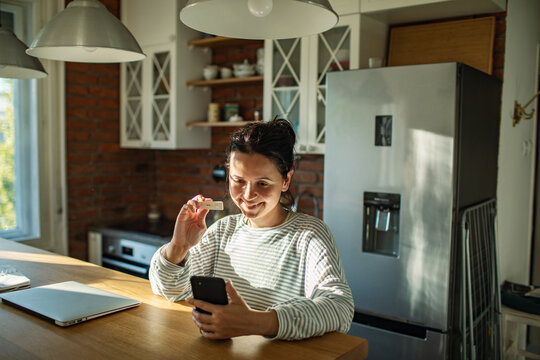 Smiling woman sharing home test result in kitchen