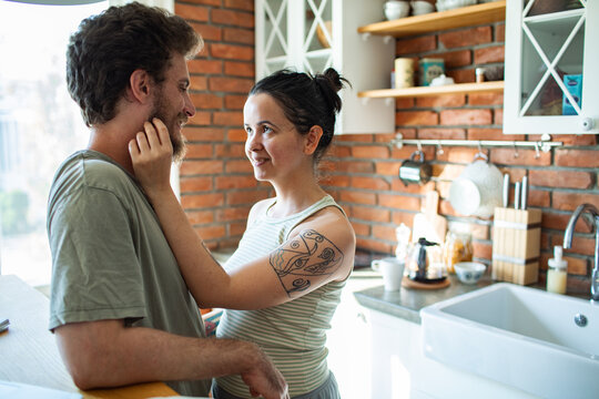 Young couple sharing tender moment in kitchen