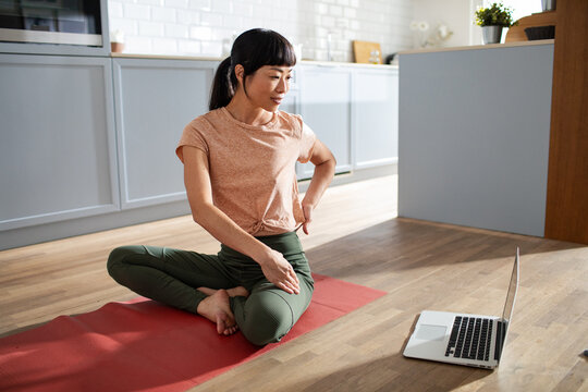 Woman following online yoga class at home