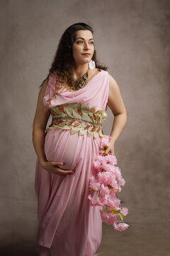Beautiful Pregnant Woman as Greek Goddess with Pink Blossoms