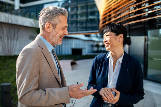 Two business colleagues chatting outside modern office
