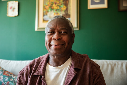 Smiling senior man sitting on sofa at home
