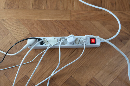 Gang socket with electric plugs kept on wooden floor