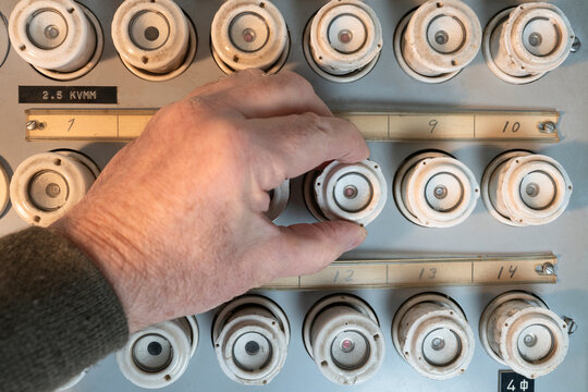 Hand of unrecognizable person plugging fuse in electrical panel