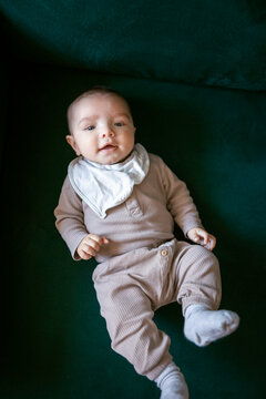 Directly above view of cute little toddler lying on green couch