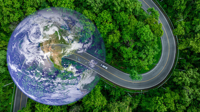 Aerial view BEV car on asphalt road with green tree forest, EV car electric vihicle car on forest road with globe earth planet, Green energy and eco power sustainable.