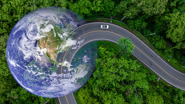 Aerial view BEV car on asphalt road with green tree forest, EV car electric vihicle car on forest road with globe earth planet, Green energy and eco power sustainable.