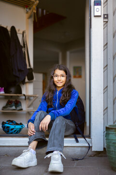 Portrait of smiling girl sitting at doorstep