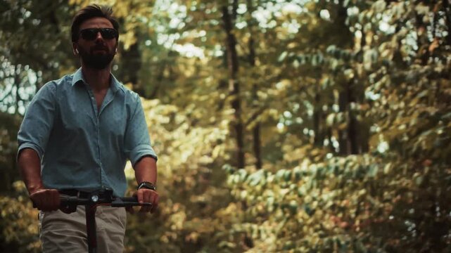 Riding Electric Kick Scooter Along Pathway In Forest Park