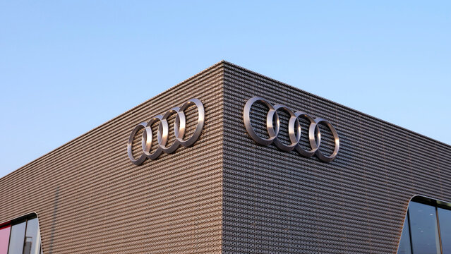 Leicester, England, UK - 17 July 2026: Audi car dealership showroom logo on perforated metal building facade against blue sky