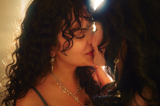 Close-up shot of affectionate lesbian women kissing in their apartment