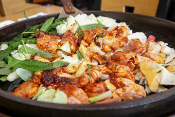 Fototapeta premium Spicy Korean Chicken Stir Fry Dakgalbi with Vegetables on Iron Pan