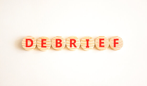 Debrief word symbol. Concept word Debrief on beautiful wooden circles. Beautiful white background. Business debrief word concept. Copy space.