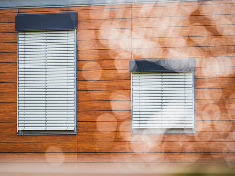 Closed window blinds seen on exterior of brown building