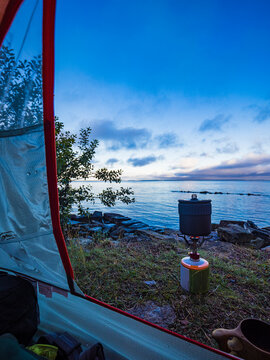 Cooking pot on camping stove near river at tranquil location