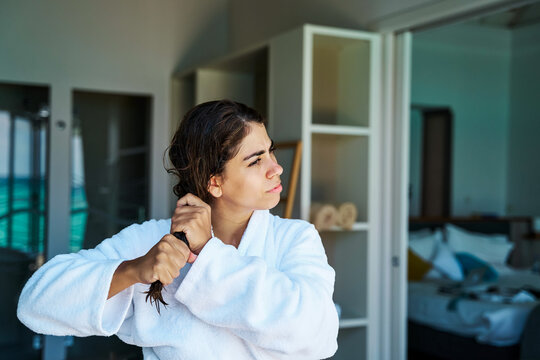 White Woman combing her wet hair in a hotel room in a hotel