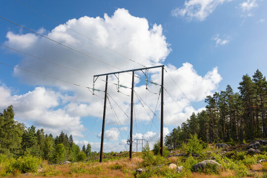 Low angle view of electricity pylons at tranquil location under cloudy sky
