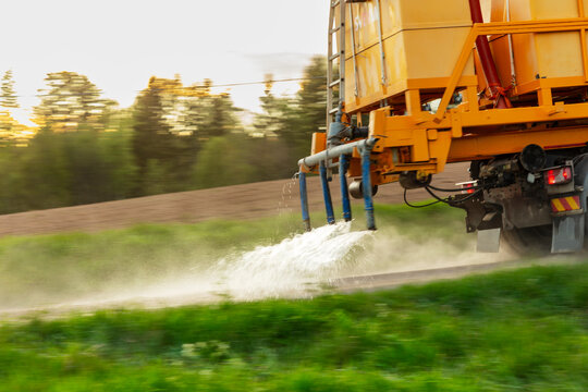 Blurred motion of truck spraying water on road for cleaning purpose
