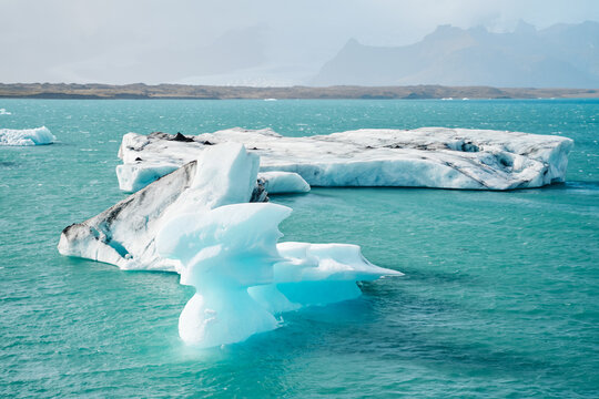 Large icebergs float in a turquoise glacial lake