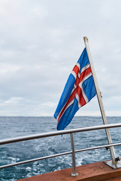 A flag fluttering on a boat at sea in Iceland