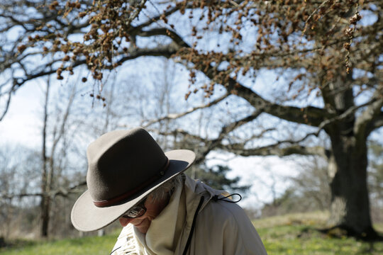 Smiling senior woman wearing hat at park during sunny day