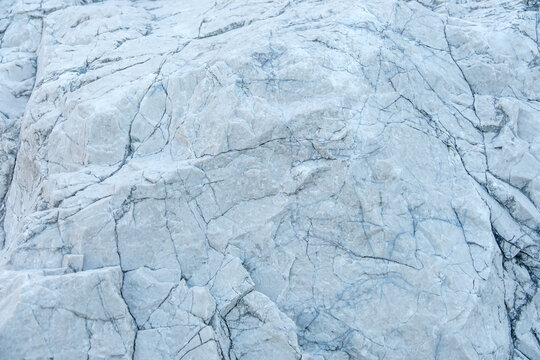 Detailed texture of natural white rock and cracked stone surface with full frame copy space for background design