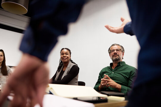 Business professionals looking up attentively at speaker during presentation