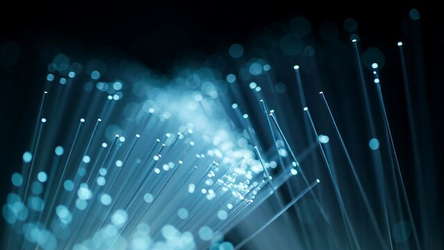 Abstract Close Up of Glowing Blue Fiber Optic Strands Transmitting Data Signals in a Dark High Speed Digital Network Environment