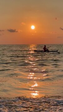 Woman's silhouette on the sup board in the sea at sunset