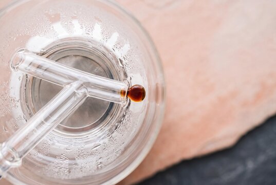 Macro View of Cold Brew Coffee Droplet Dripping from Glass Pipe in Cold Drip Tower