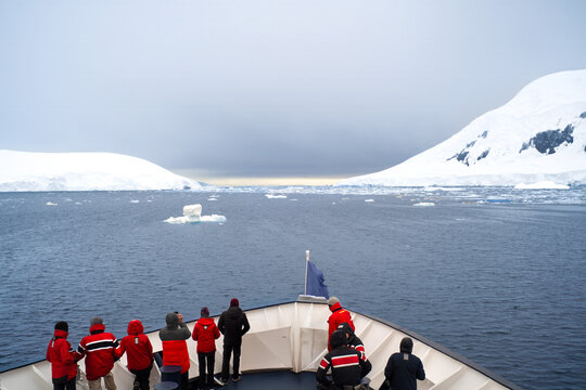 Antarctica, Antarctic Peninsula, Passengers on deck looking forward to enter the Lemaire Cannel in February 