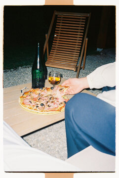 Homemade pizza and cider on an outdoor patio