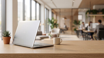 Fototapeta premium Laptop and succulent plant on wooden desk in modern blurred office workspace