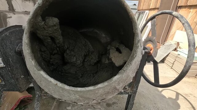 A Close-Up View of a Cement Mixer with Freshly Mixed Concrete, Showcasing the Thick, Muddy Consistency Perfect for Construction Activities and Projects