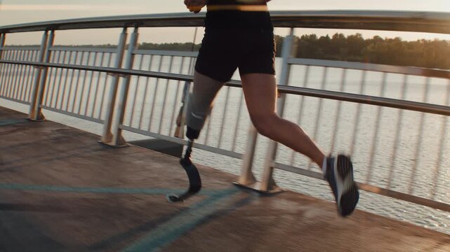 Male athlete with running prosthesis sprints against river