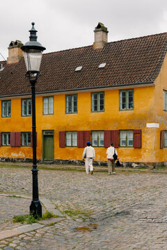 Couple strolling through historic Copenhagen streets on a cloudy day