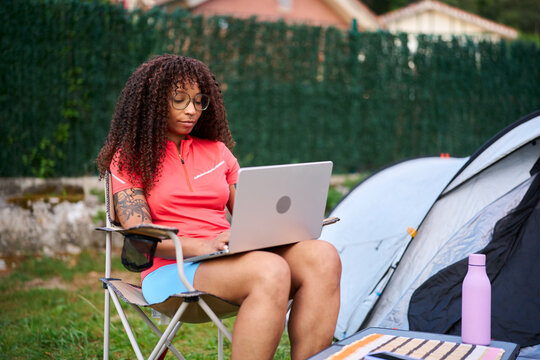 Woman working remotely at campsite as digital nomad