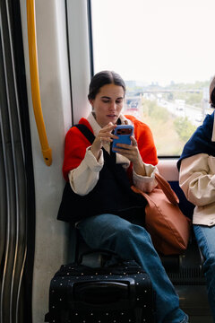Female tourist uses smartphone on Copenhagen public transport on trip