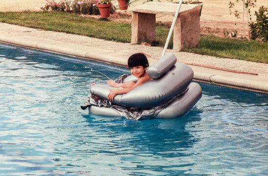 Young boy enjoying summer fun in a swimming pool float