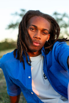 Portrait of young man with dreadlocks looking at camera