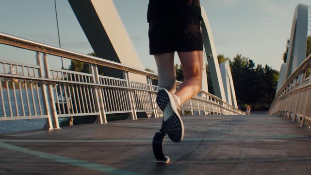 Runner with leg prosthesis continues workout along footbridge