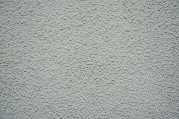 Close up of a white exterior wall with a heavy, bumpy roughcast stucco finish. A clean, uniform architectural texture ideal for blank backdrops and design overlays. © Okta