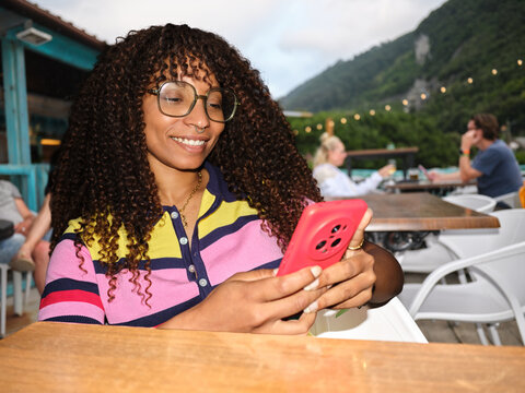 Woman using smartphone connecting outdoors at cafe