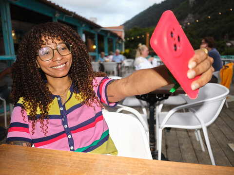 Happy woman taking selfie at outdoor cafe