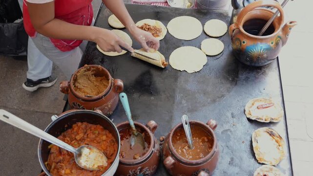 Mexican street food vendor preparing tacos on a comal