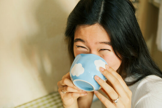 Close up portrait of happy beautiful asian woman having coffee